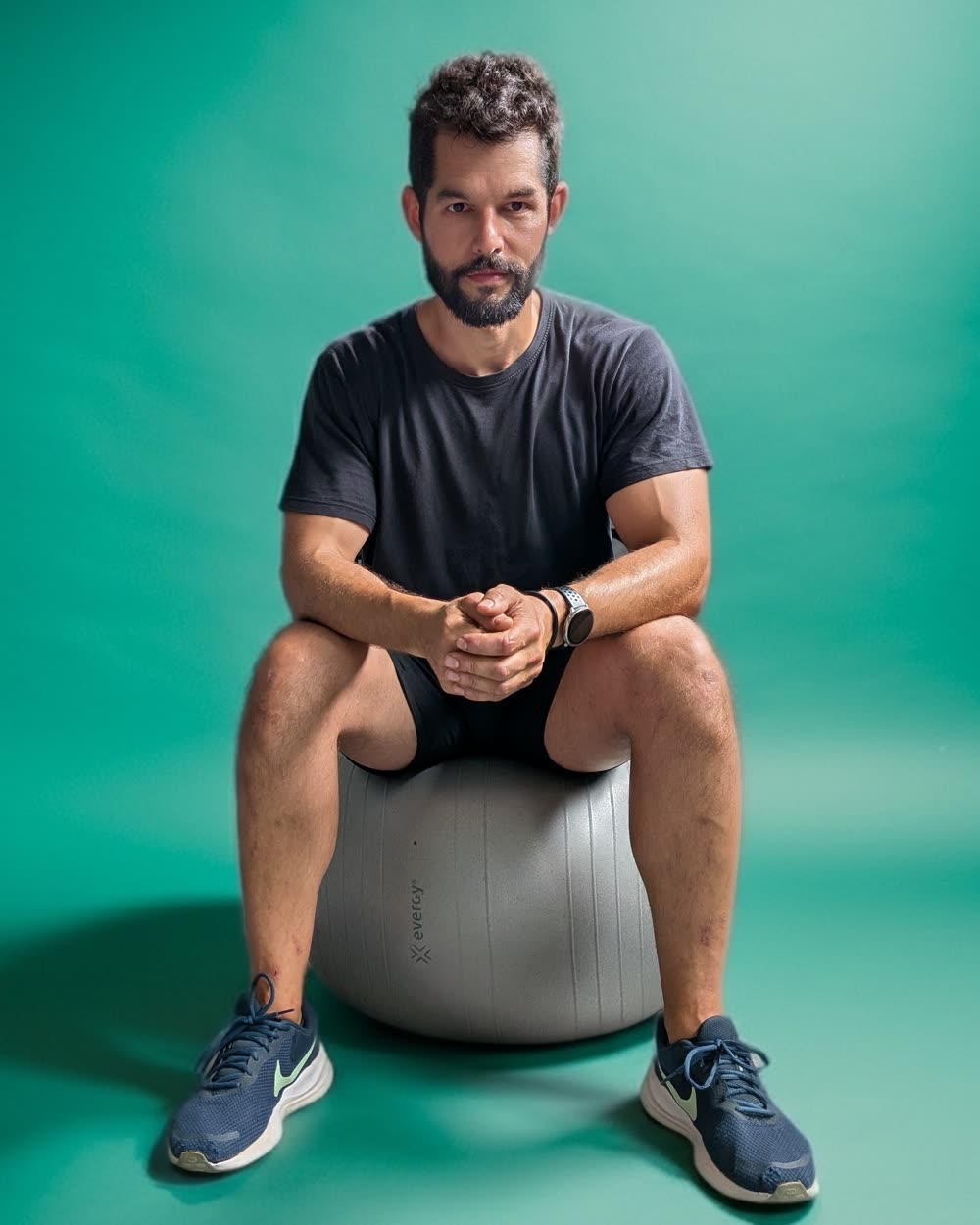 Alberto, entrenador personal, sentado en un fitball mirando a cámara
